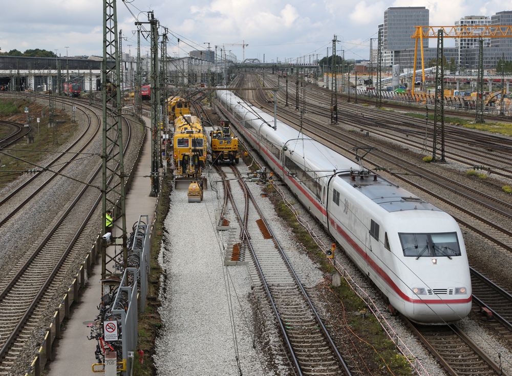 Le train blanc avec une bande rouge passe l'équipement d'entretien