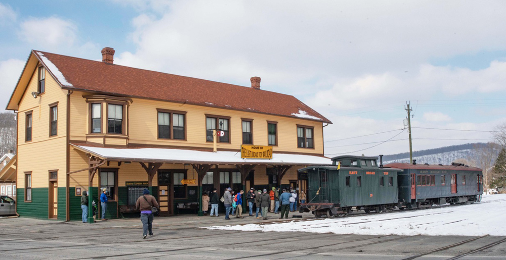 Railcar and caboose in front of station building