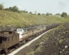 Four-unit streamlined diesel set on rear of freight train ahead of caboose