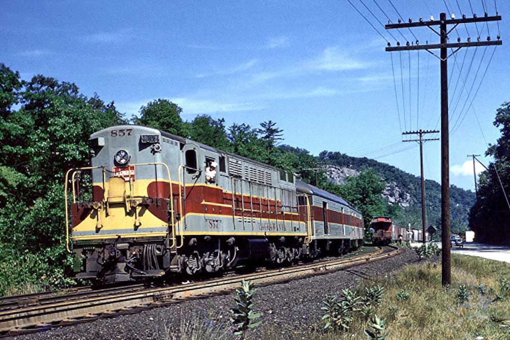 Boxy diesel locomotive with passenger train on curve