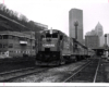 Conrail passenger trains: Locomotive leads a train away from a big-city downtown.