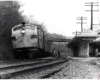 Conrail passenger trains: A beat up streamlined locomotive at the head of a passenger train at a station.