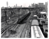 Conrail passenger trains: Old electric locomotive at the head of a passenger train in a stub-end siding in a rail yard.