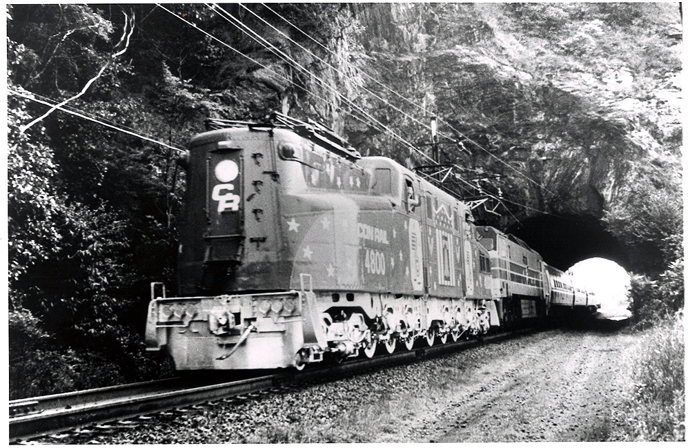 Conrail passenger trains: A streamline electric locomotive hauls a passenger train through a stone tunnel.