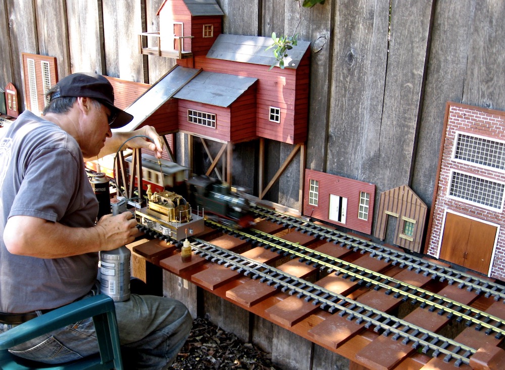 Man maintaining model live-steam engine.