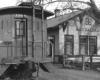 Caboose next to wooden train station.