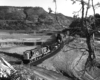 Short freight train winding through a wide river valley.