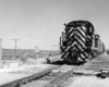 Black and white stripped locomotive paused at a switch.