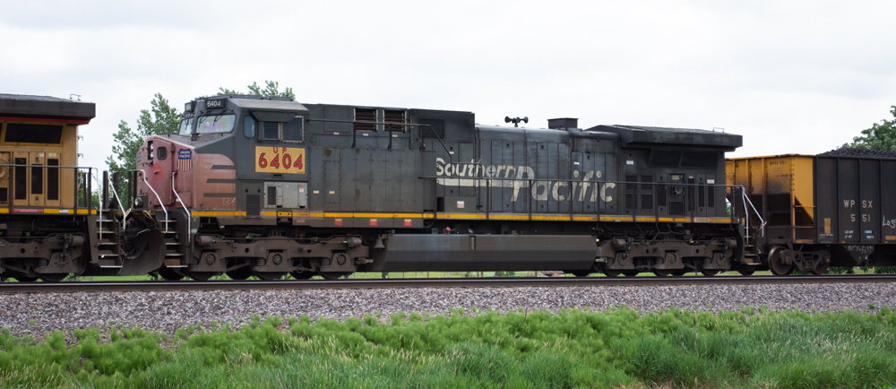 Photo of red and gray General Electric AC4400CW with white graphics and yellow patch with red numbers and letters under the cab.