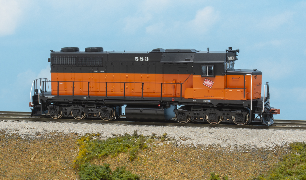 Photo of HO scale EMD SDL39 painted orange and black on scenicked base.