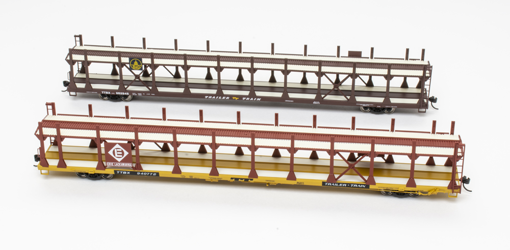 Photo of two HO scale 89-foot flatcars with bi-level auto rack on white background.
