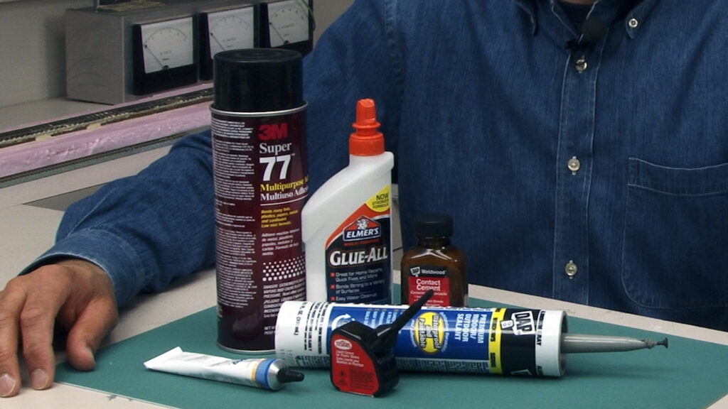Several types of glues and adhesives shown on a workbench