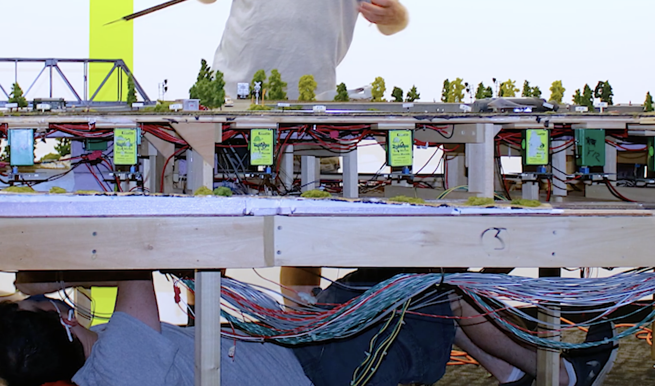 A man working on the wires underneath the layout.