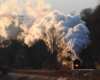 Pre-dawn light illuminates the great plume as the steam engine pulls the train
