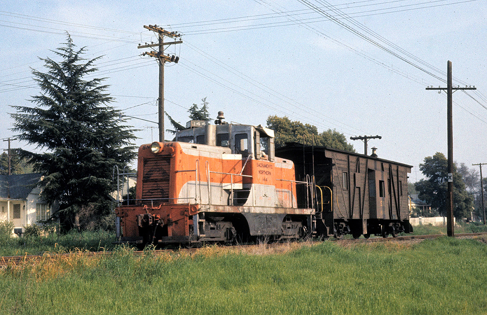 Orange and light grey locomotive working a freight train.
