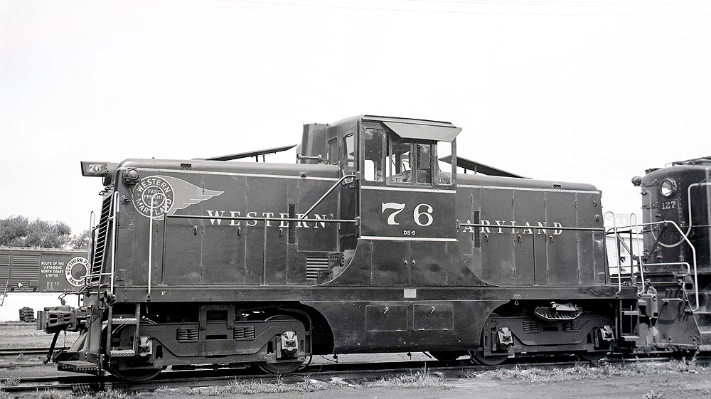 Center cab locomotive with prominent headlamps on front and rear.
