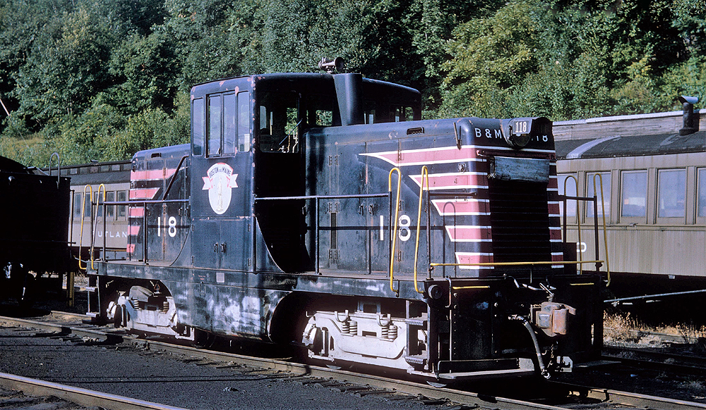 Mostly black center-cab locomotive in a rail yard.