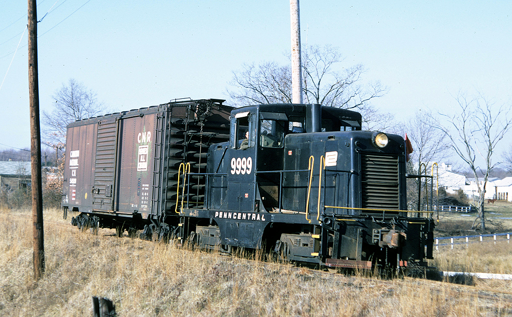 Black locomotive with white letters hauling freight.