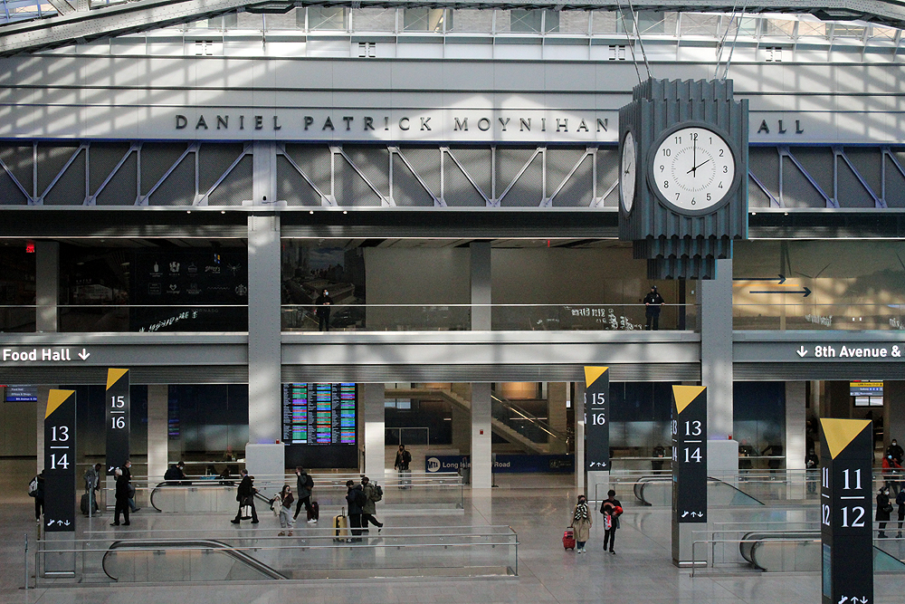 Daytime view of train hall including large clock.