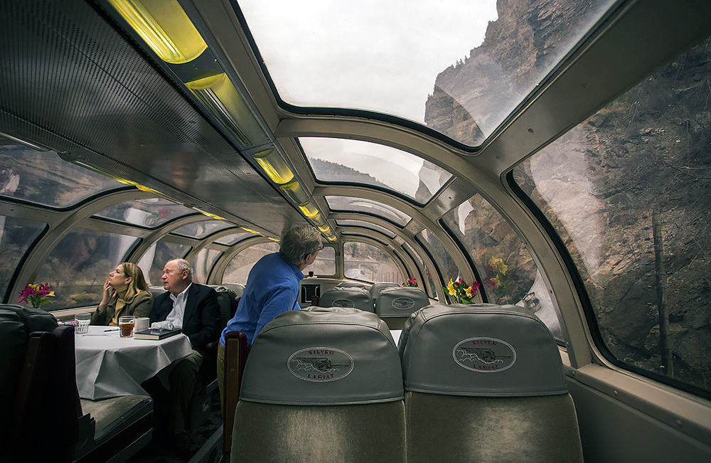 Passengers enjoy scenery from the dome of a passenger car.