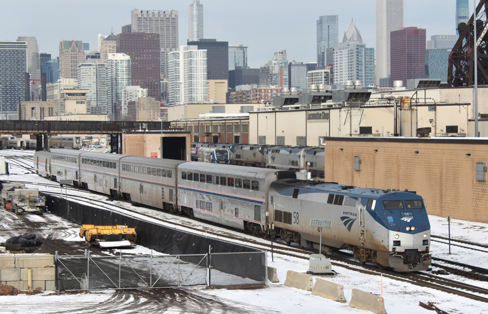 Five-car passenger train with Chicago skyline in background