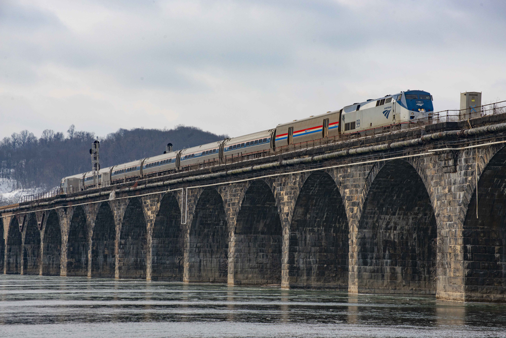 Passenger train on stone-arch bridge