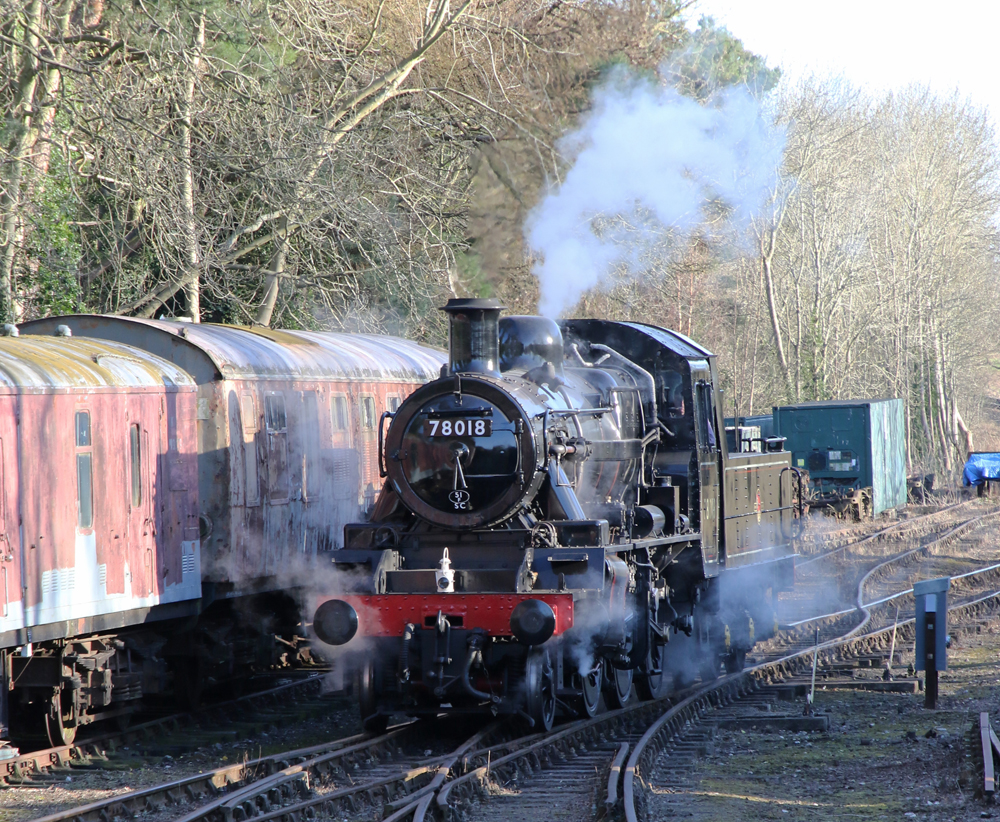British steam locomotive next to passenger cars