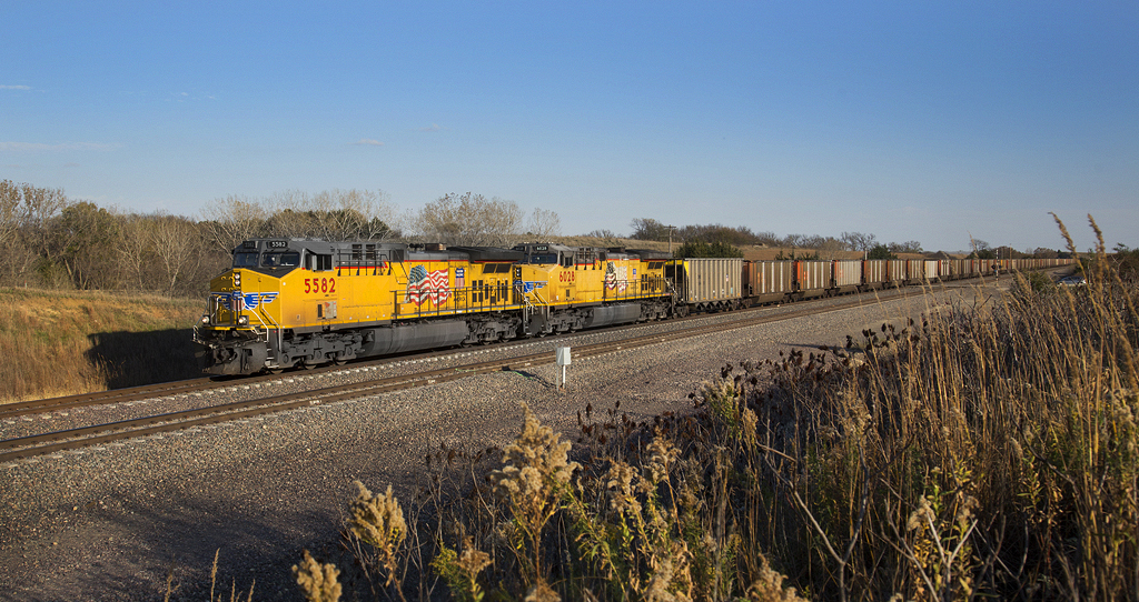 Two yellow locomotives with trains of coal hoppers