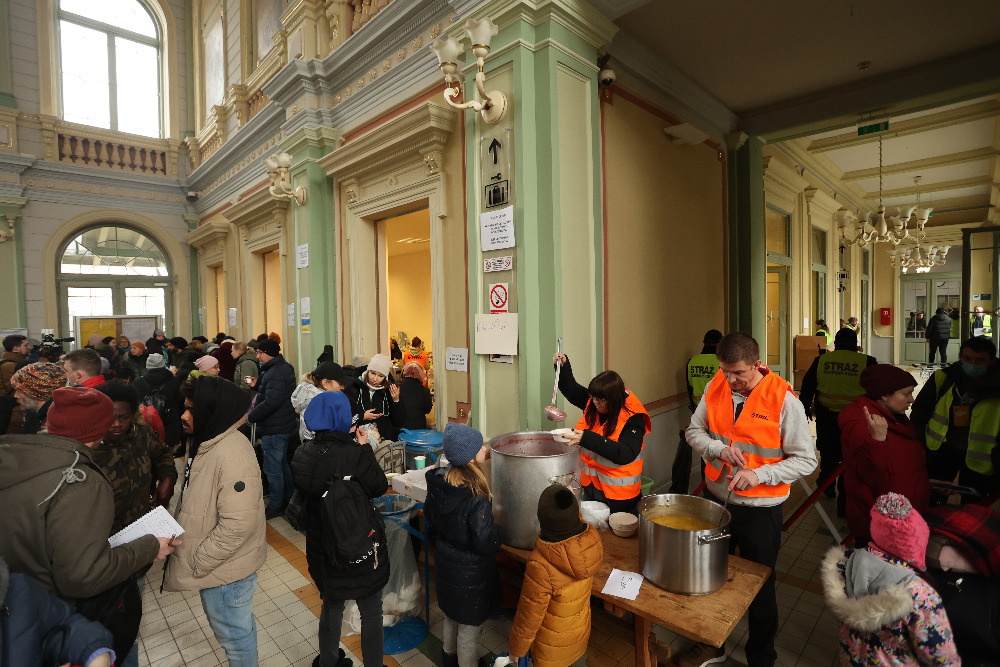Crowded train station, with some people receiving food