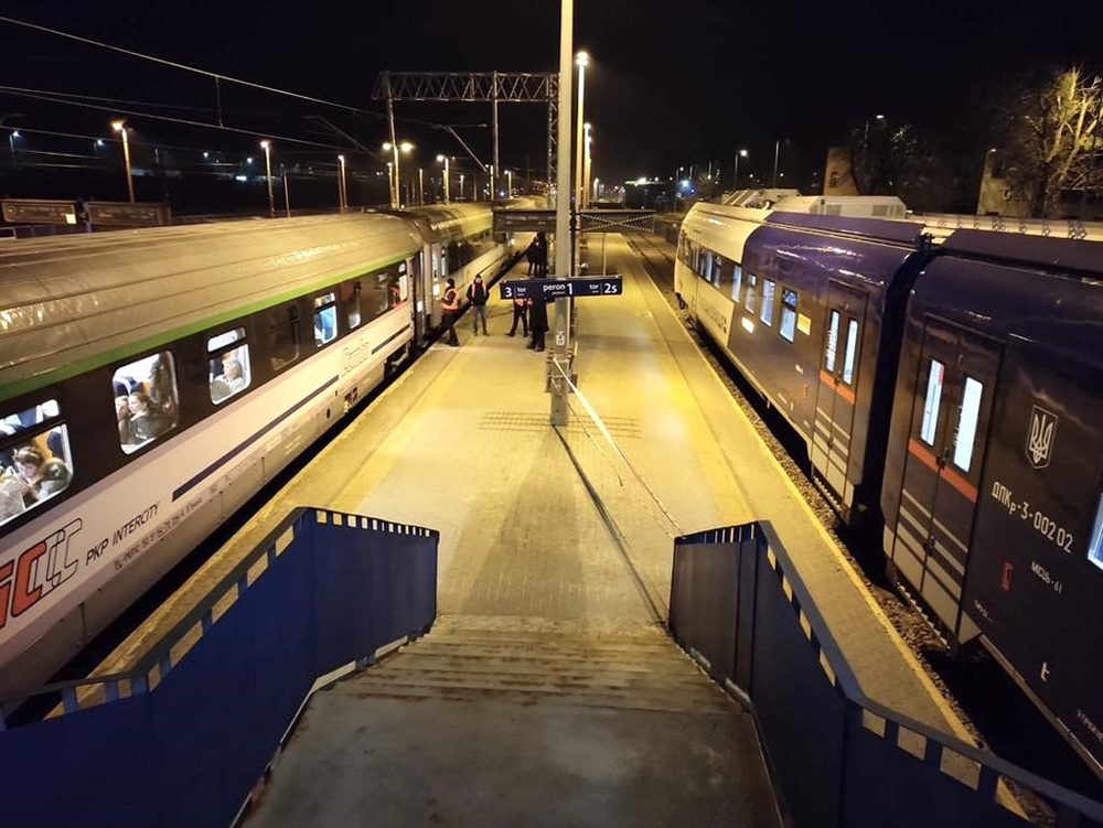 Trains on opposite sides of station platform at night