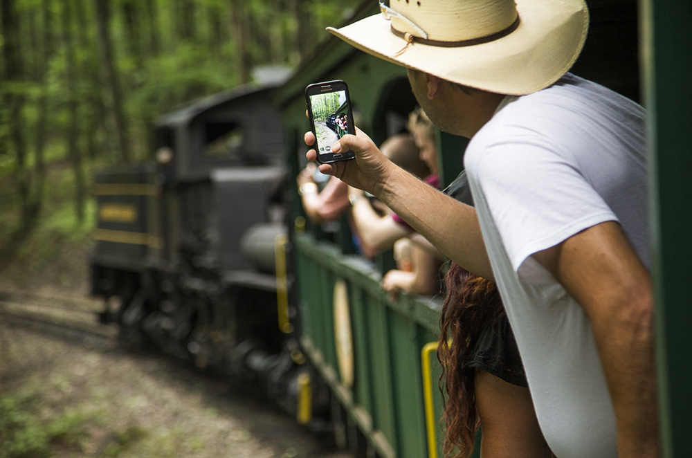 Man on train taking picture with cell phone