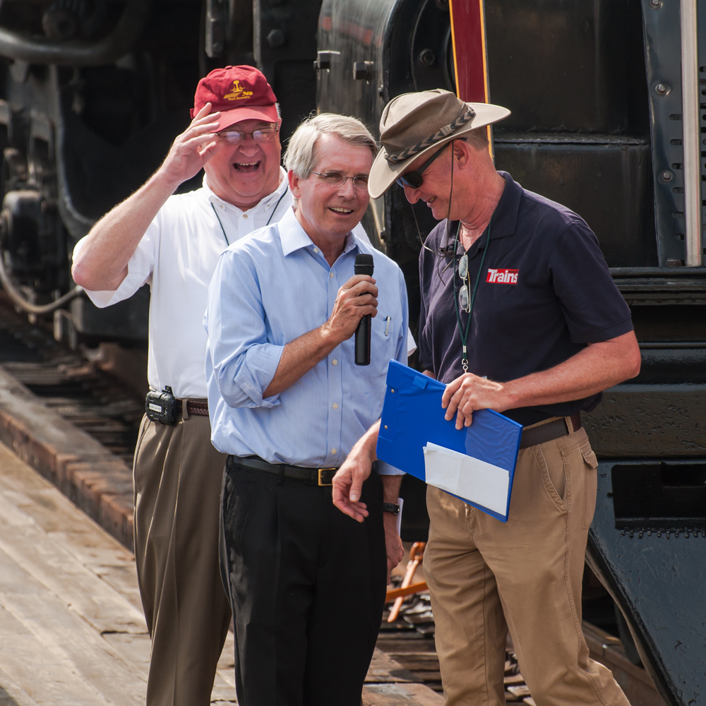 Three smiling men talking