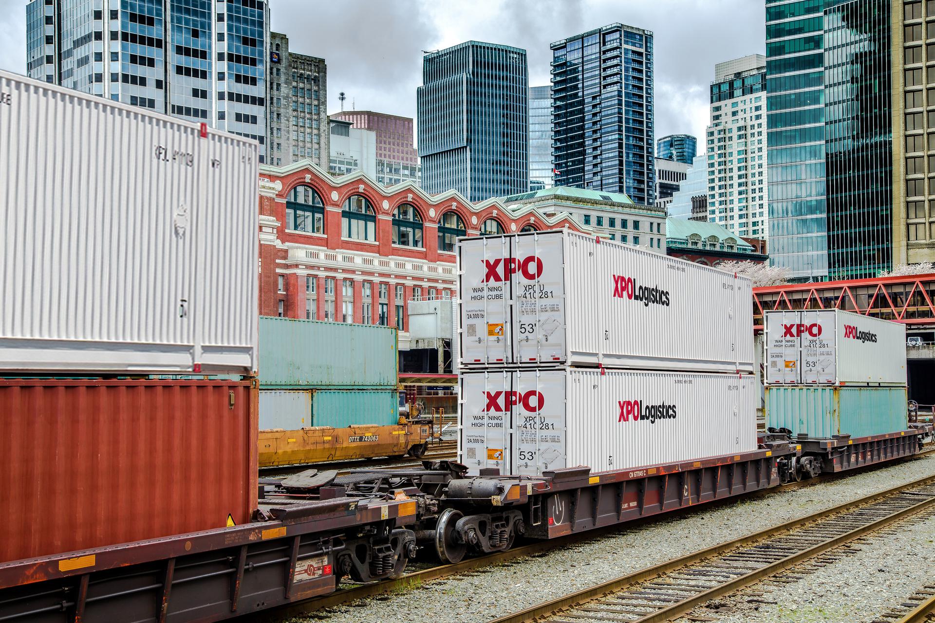 XPO Logistics containers on train with city skyline in background