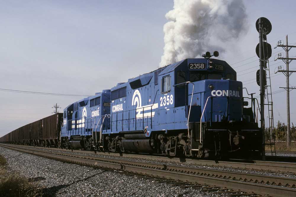 Blue diesel locomotives with train of open hoppers