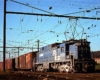 Blue electric locomotive with Conrail freight train under wires