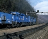 Two blue Conrail locomotives behind caboose under signal bridge
