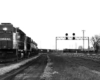 Conrail freight train at left while second train approaches in distance under signal bridge