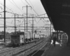 Rear of Conrail freight train with trailers on flatcars passing station on electrified trackage