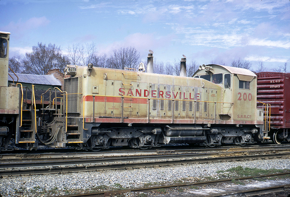 Diesel locomotive single order units: Grimy gray diesel locomotve in a rail yard.