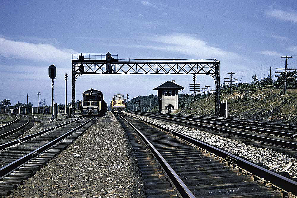 Distant locomotives on a railroad mainline in a color photograph.