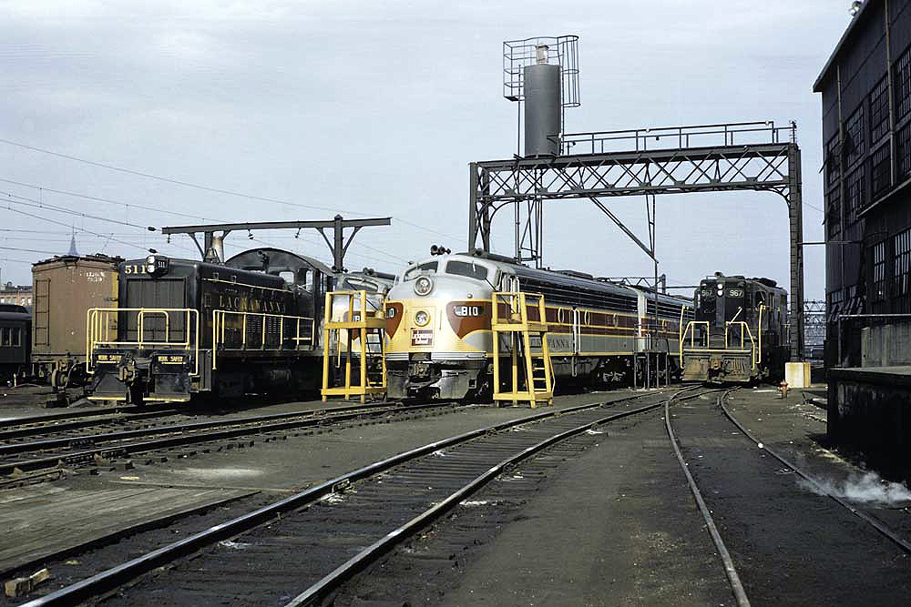 Grey and maroon cab unit in a rail yard in a color photograph.