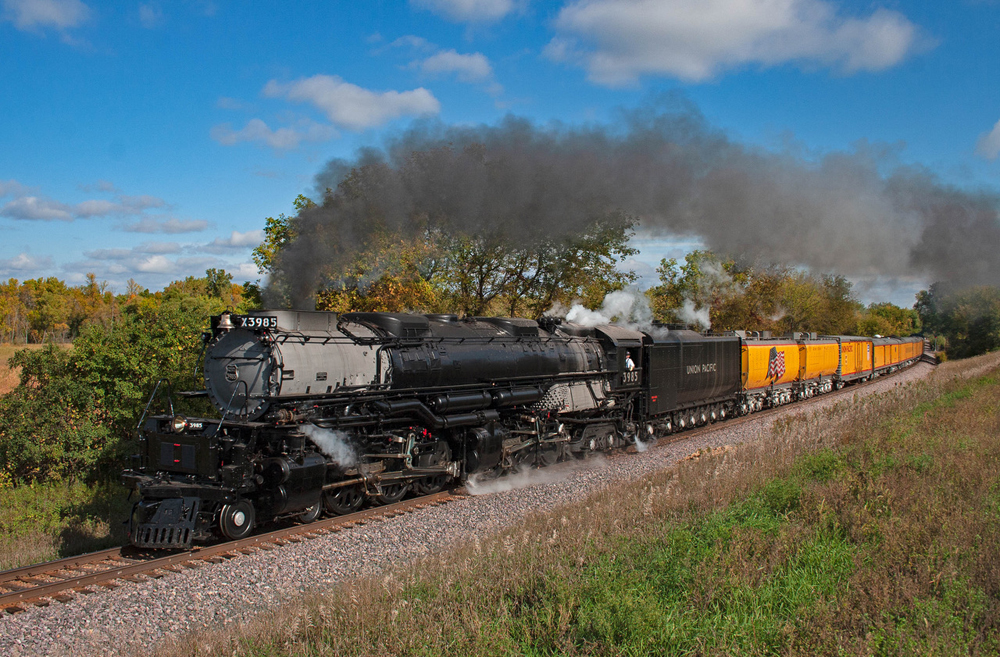 Large steam locomotive with yellow passenger cars