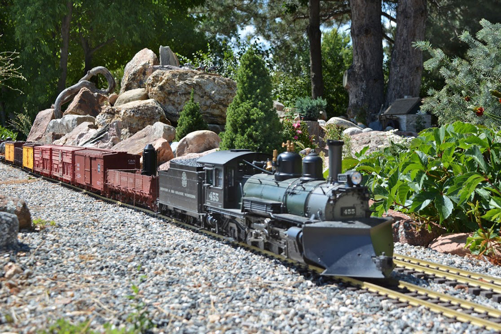 Model steam train with snowplow on tracks