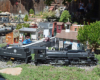 Model steam locomotive passes by a town