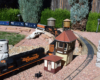 Model diesel engine speeding by curve with watch tower nearby