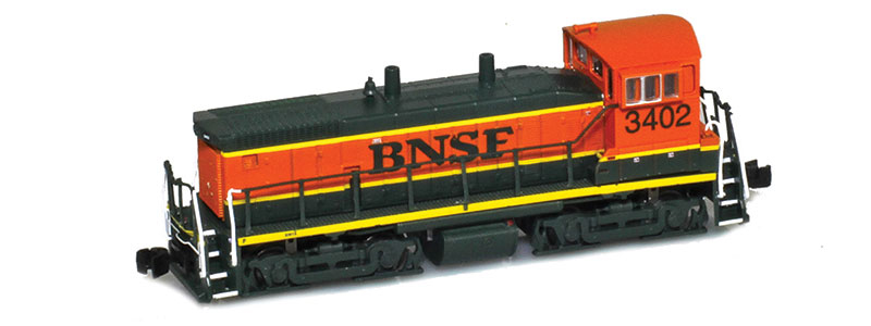 Photo of Z scale diesel locomotive painted orange, green, and yellow.