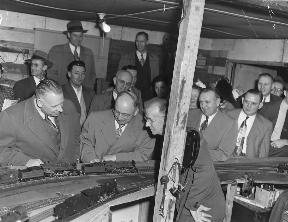 Men in suits looking at trains