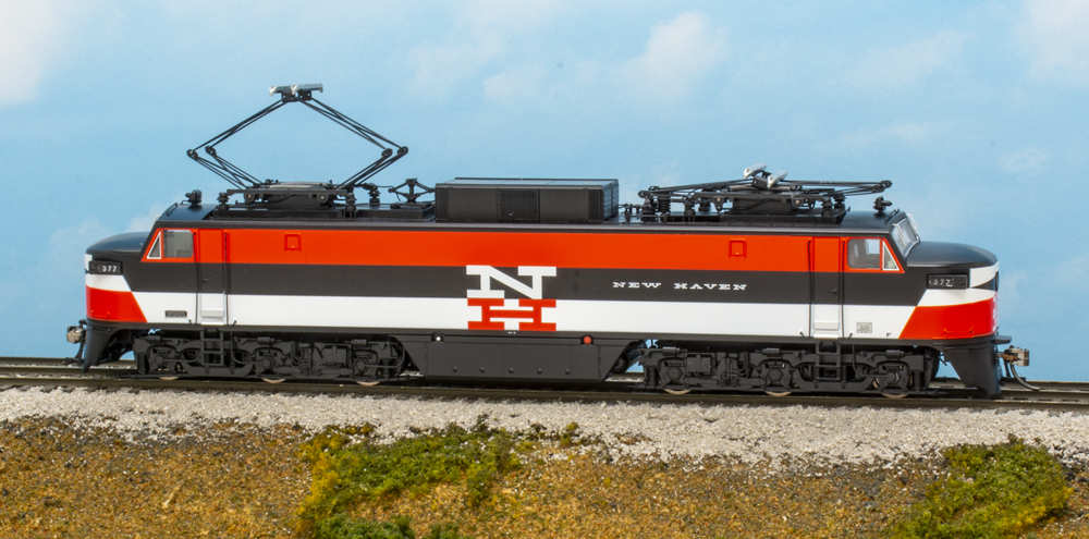 Photo of HO scale electric locomotive in orange, black, and white paint scheme.