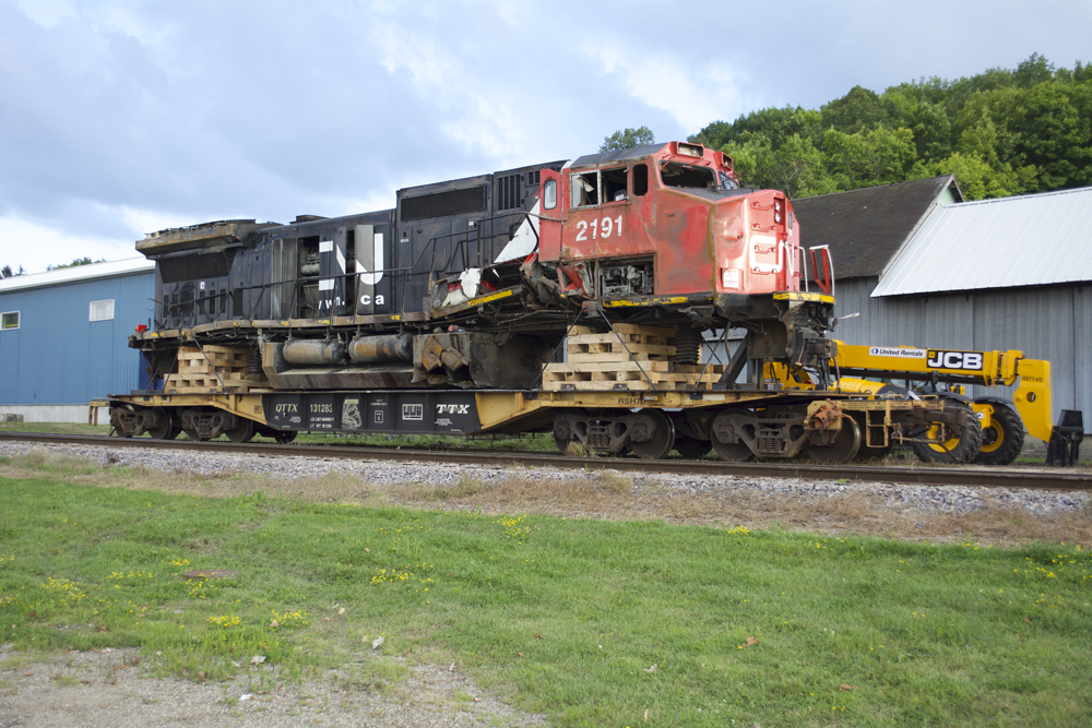 Transporting a damaged locomotive: Yellow-and-black flatcar with locomotive load.