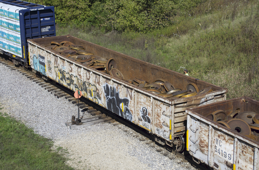 Photo of gondola painted light gray with rusty interior.